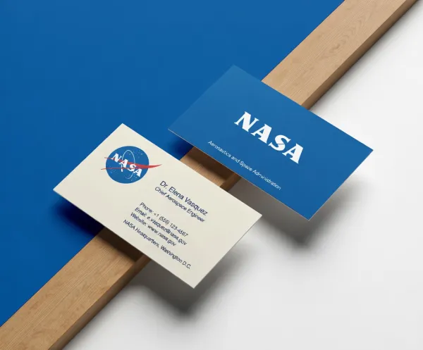 Create a modern business card mockup using the uploaded logo. Two cards are arranged diagonally on a background that automatically matches the brand’s colors. One card features a clean light design, while the other uses the primary brand color. Include simple contact details and realistic textures. Soft studio lighting, slight overhead perspective, clean and professional style.