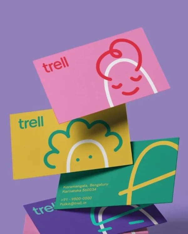 Create a professional business card mockup for the uploaded brand. The scene features a dynamic, gravity-defying arrangement of exactly three business cards floating and cascading in mid-air against a solid, vibrant background.

Each of the three cards showcases a unique color pairing derived from the brand's primary and secondary palette. The top two cards prominently feature the brand’s logo and its signature graphic icons or illustrations. The third card is positioned to show the reverse side, displaying contact information such as address, phone number, and email in clean, minimalist typography.

The lighting is soft and directional, casting realistic shadows between the three floating cards to create depth and a sense of three-dimensional space. The perspective is a close-up, angled shot that emphasizes the cards' clean edges and high-quality texture. The overall aesthetic is playful, modern, and premium, using bold color blocking to ensure the presentation perfectly adapts to the uploaded brand's visual identity.
