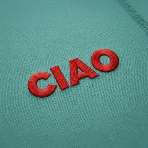 Close-up fabric mockup showing uploaded logo embroidered on textured fabric in brand color. Soft diffused lighting highlights fabric texture and embroidery detail, subtle 3D effect, clean and minimalist style.